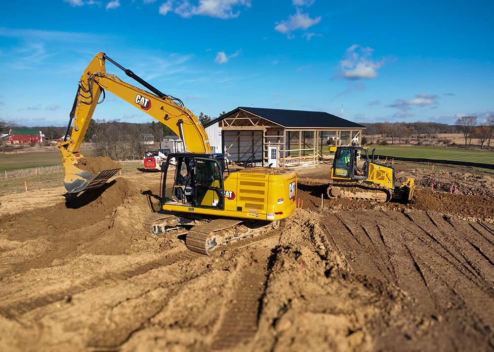 CAT excavator and bulldozer performing site preparation for pole barn construction in Chelsea Michigan