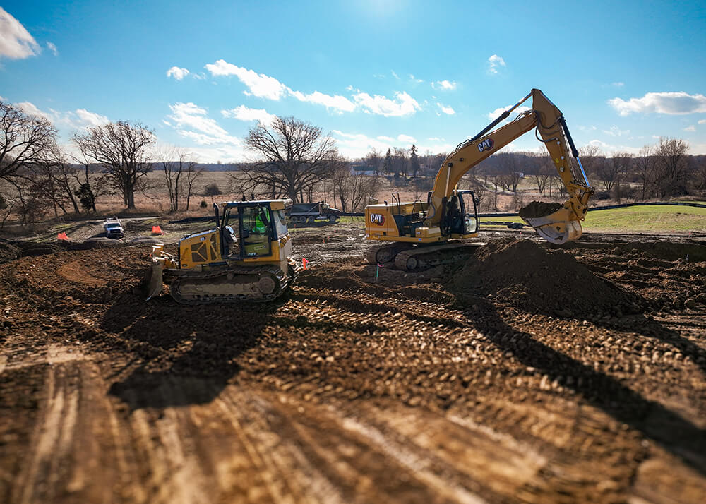 CAT excavator and bulldozer performing site preparation and grading for a construction project in Washtenaw County Michigan