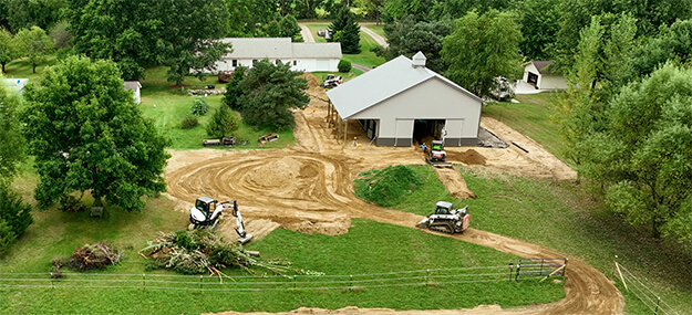 Equestrian facility site preparation and grading work around barn construction on rural property