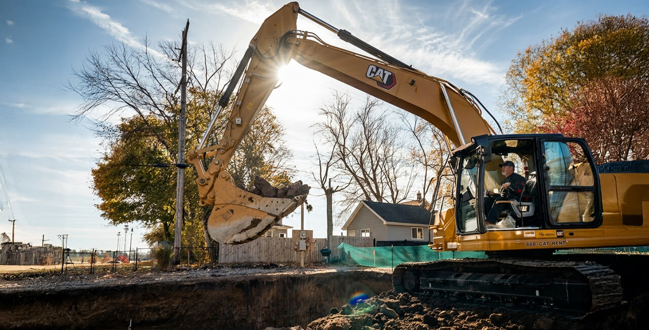 Excavator digging and shaping construction site for foundation and site preparation work