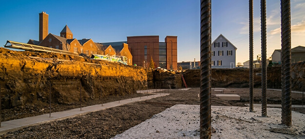 Foundation footing trenches with rebar layout and compacted base at construction site in Ann Arbor Michigan